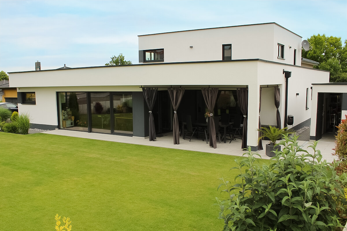 Bungalow mit Aufbau von SYSTEM MASSIVHAUS mit Walmdach und Staffelgeschoss