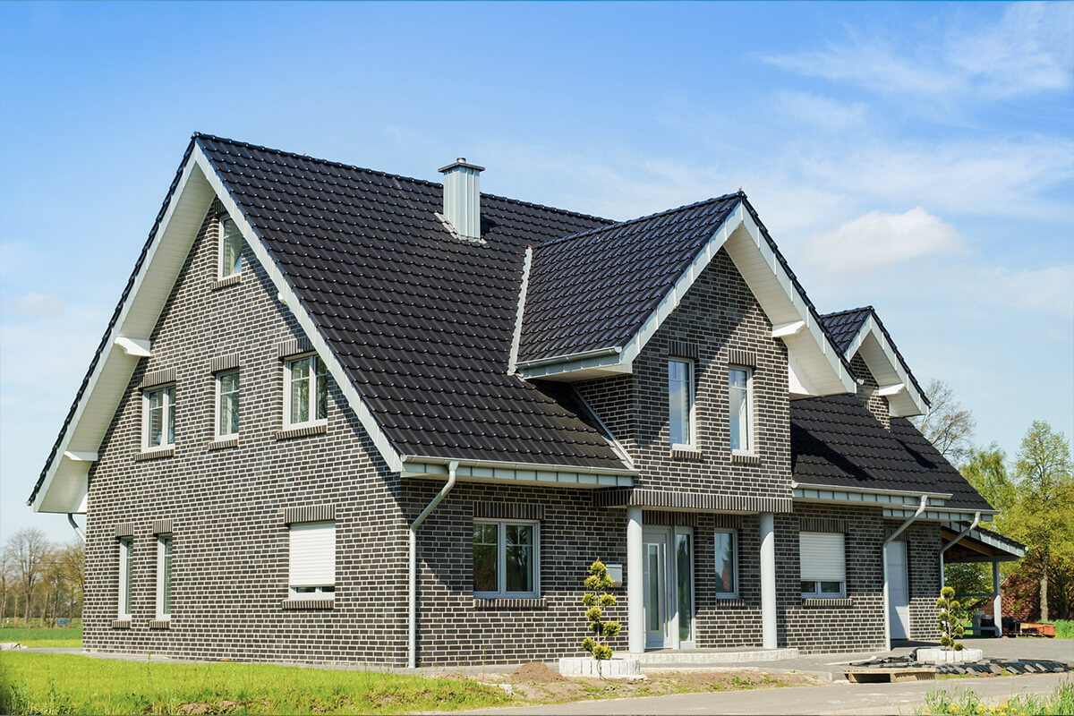 Massivhaus von SYSTEM MASSIVHAUS mit Satteldach grau verklinkert